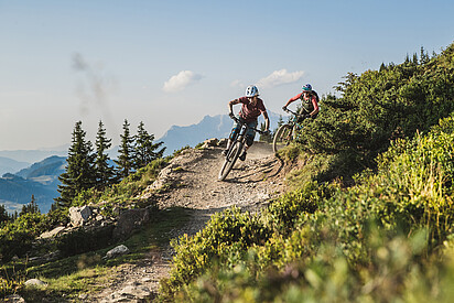 Two downhill bikers in the mountains of Saalbach Hinterglemm