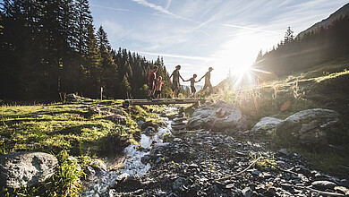 Family walking over bridge, Saalbach Hinterglemm valley head