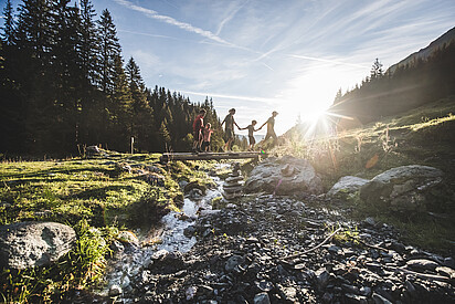 Family walking over bridge, Saalbach Hinterglemm valley head