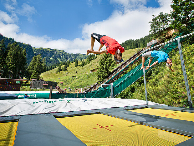 Mann springt auf einem Trampolin im Jump and Slide Park in Saalbach Hinterglemm