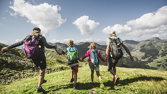 Familie beim Wandern in den Bergen in Saalbach Hinterglemm